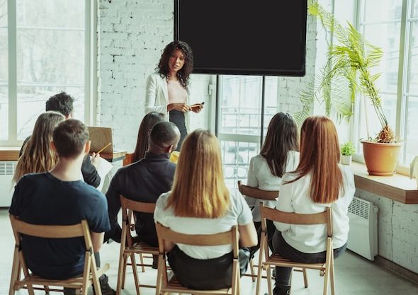 female-african-american-speaker-giving-presentation-hall-university-workshop_155003-3579